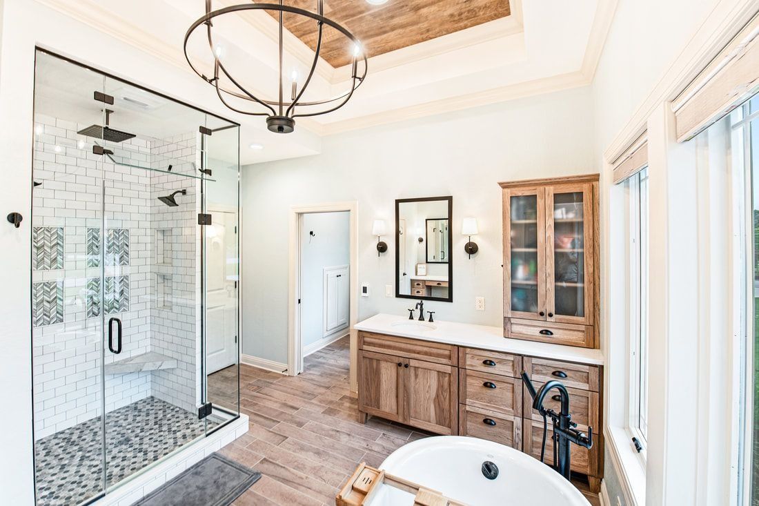 Spacious bathroom with glass shower, wooden vanity, and freestanding tub.