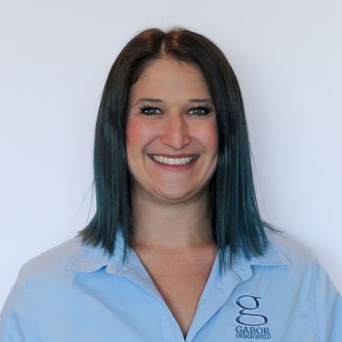 Jessica with teal-tipped hair smiles, wearing a light blue polo shirt with 