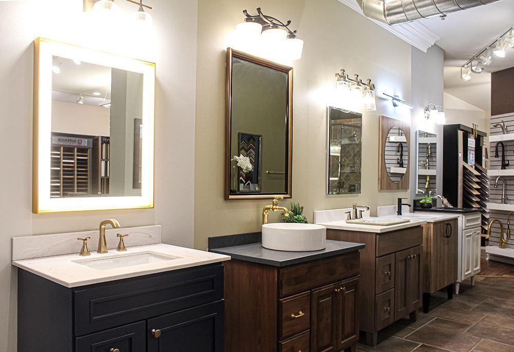 Bathroom vanities display in a showroom, with mirrors, lighting, and various cabinet styles.