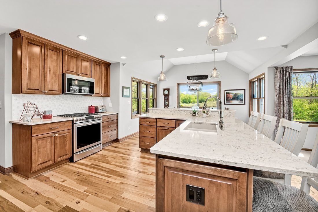 Spacious kitchen with wood cabinets, countertops, and island. Stainless steel appliances and natural light.