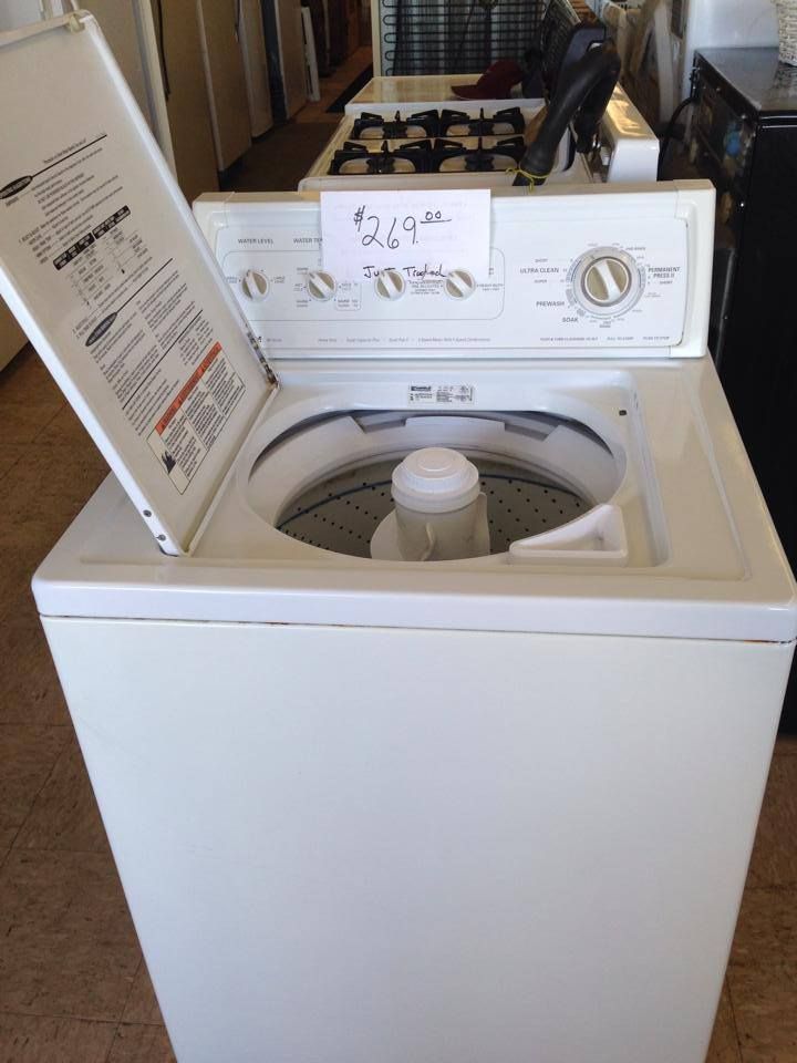 A white washing machine with the lid open and a price tag on it