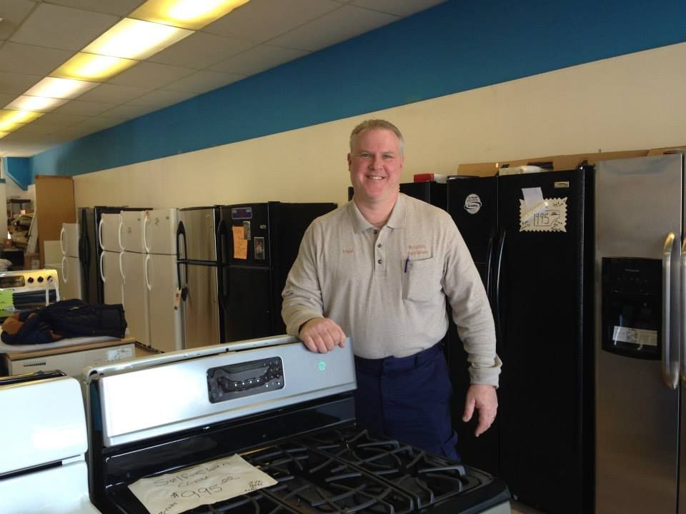 A man standing next to a stove in a store