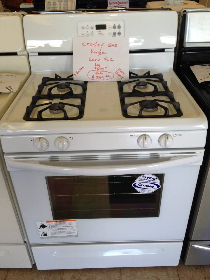A white stove with a sign on it that says