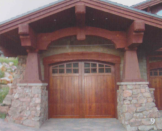 Wooden garage with stone columns, framed by a dark wood arch and roof.