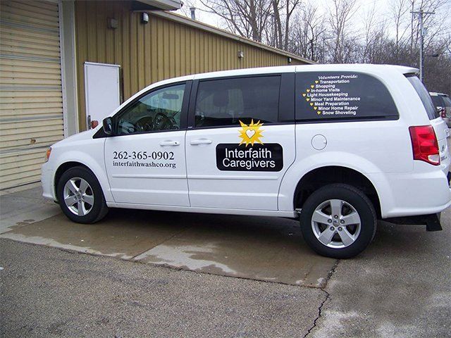 A white van with interfaith caregivers written on the side