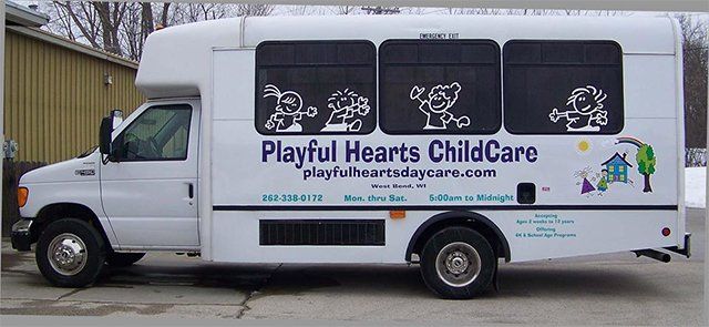 A playful hearts childcare bus is parked in the snow