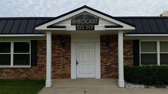 A brick building with a sign that says rheocast tool shop
