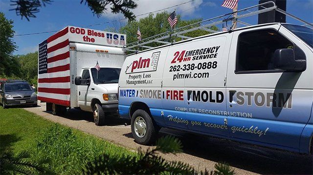 A row of vans are parked on the side of the road.