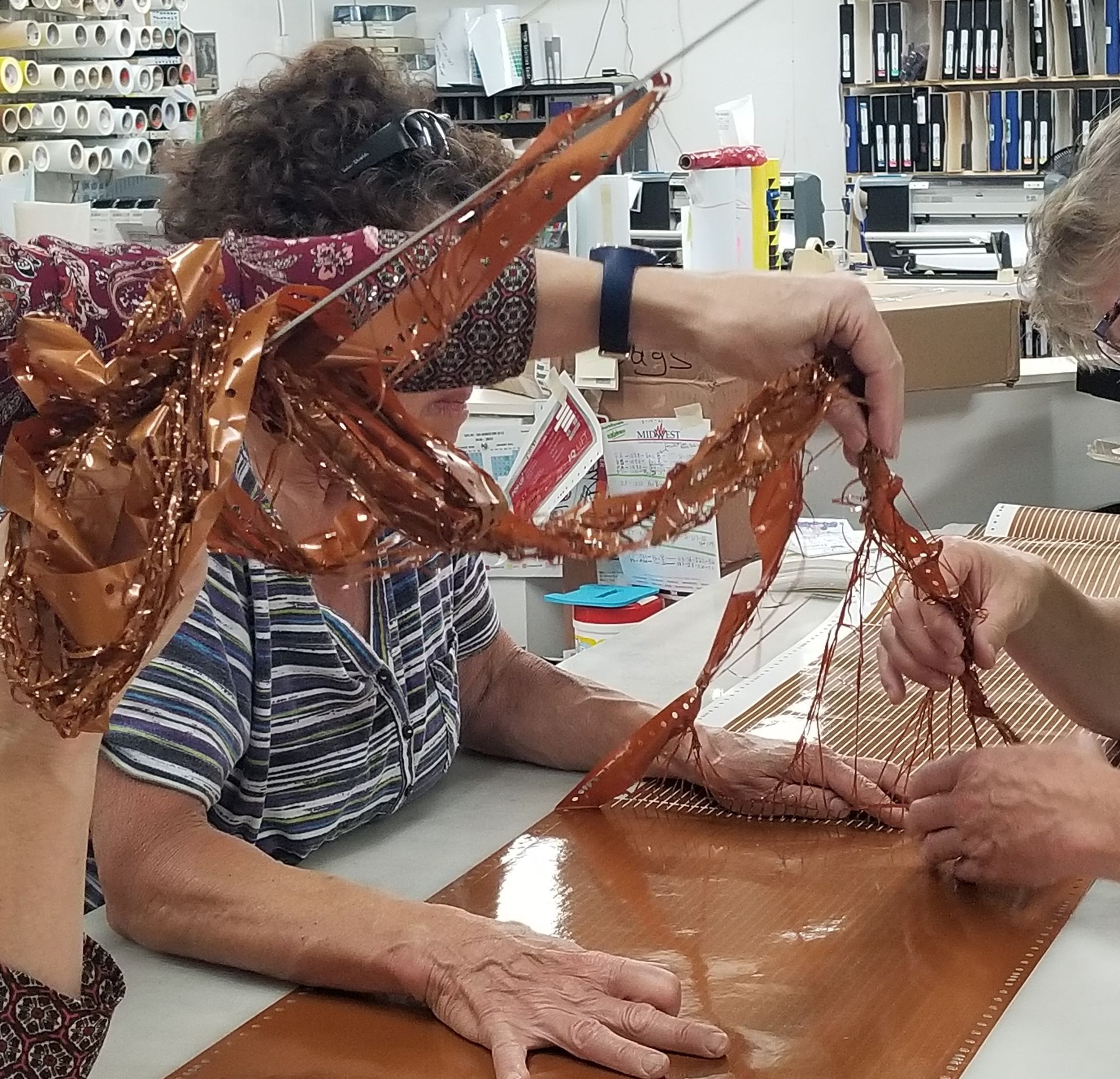 A group of people are working on a piece of copper