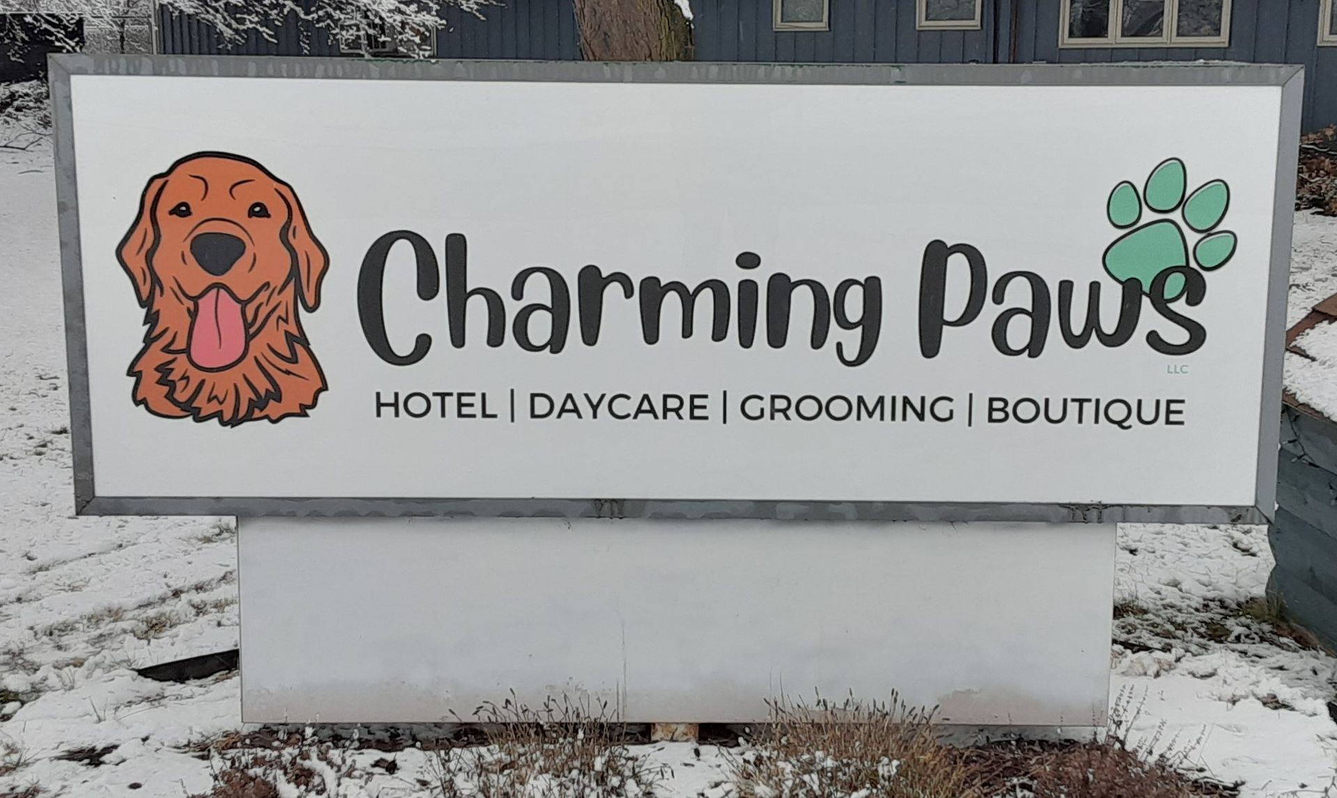 A sign for charming paws hotel daycare and grooming boutique