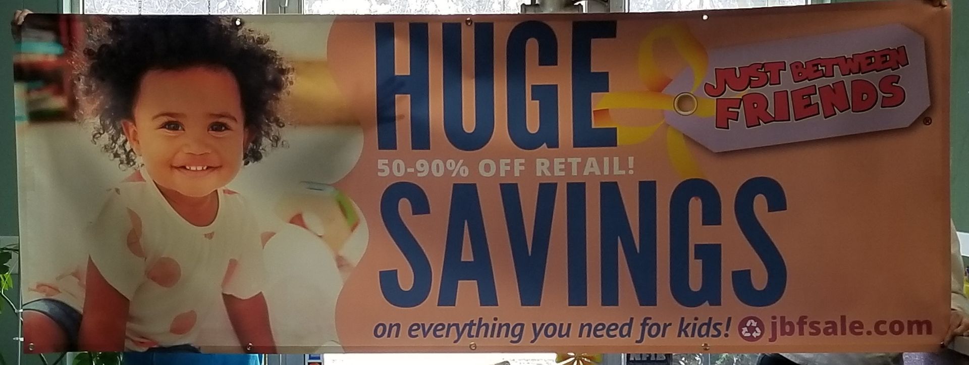 A sign that says huge savings on everything you need for kids