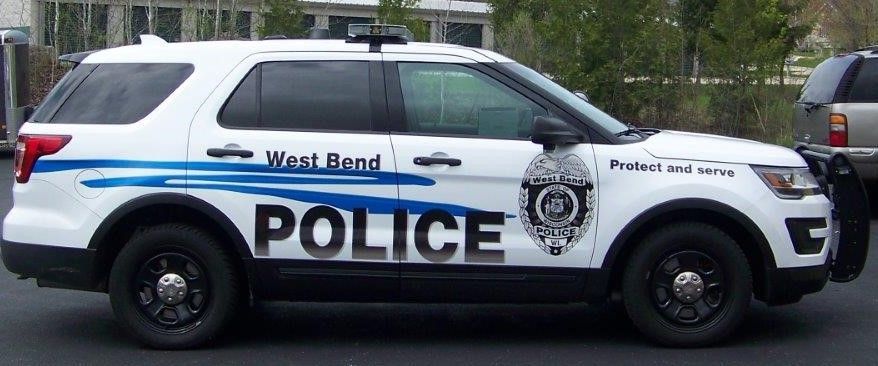 A west bend police car is parked on the side of the road