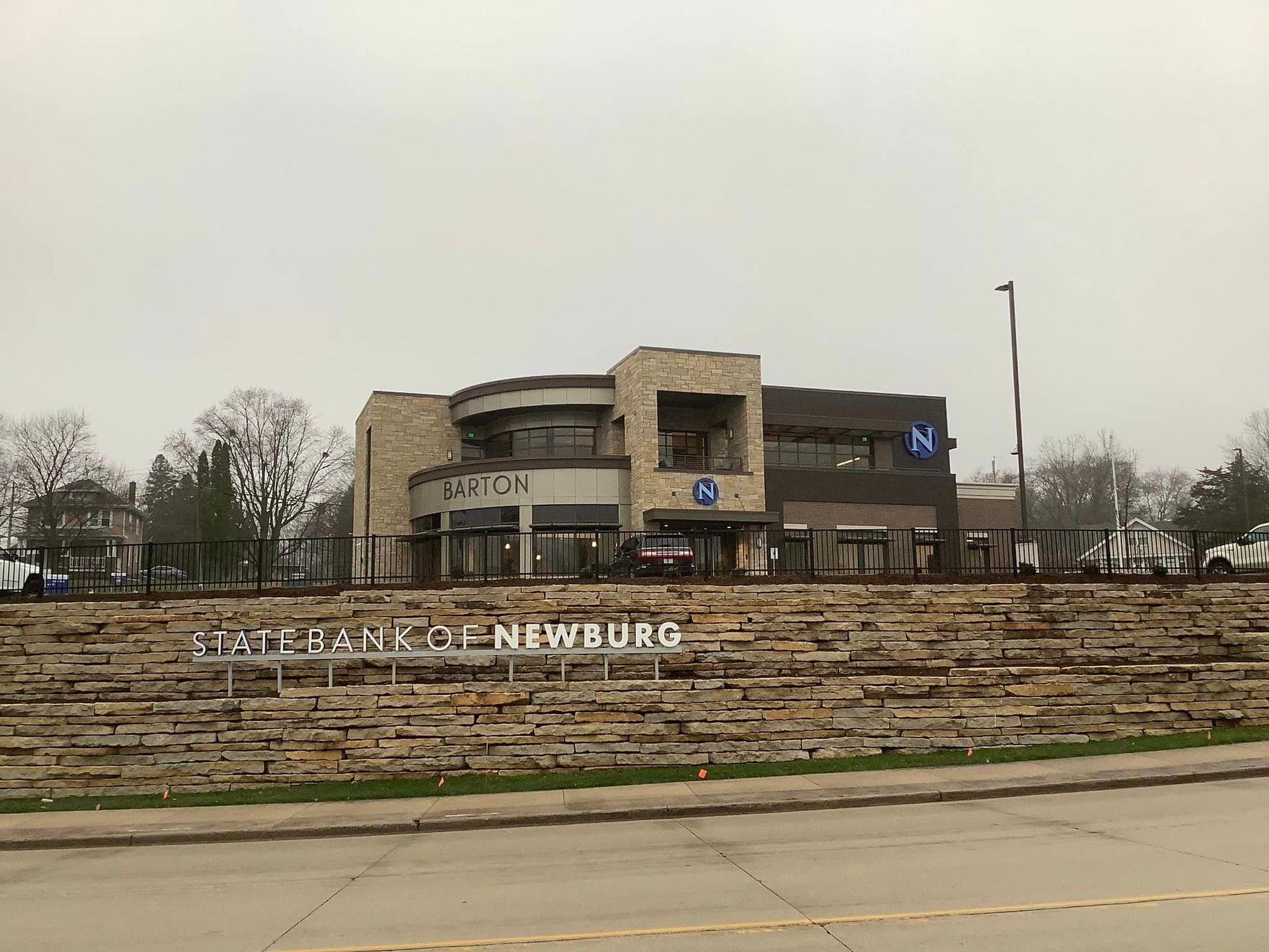 Bank building with stone facade and sign ONE BANK FOR NEWBURG on a cloudy day.