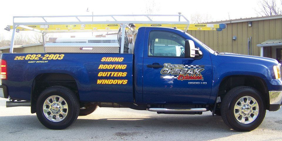Blue pickup truck with company logo and services listed.