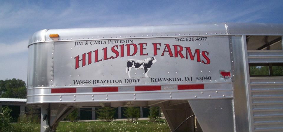 Silver trailer with HILLSIDE FARMS logo, a cow graphic, and address in Kewaskum, WI.