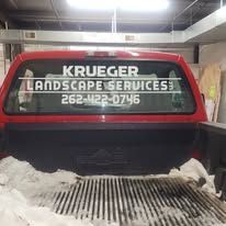 Red pickup truck with Krueger Landscape Services on the rear window.