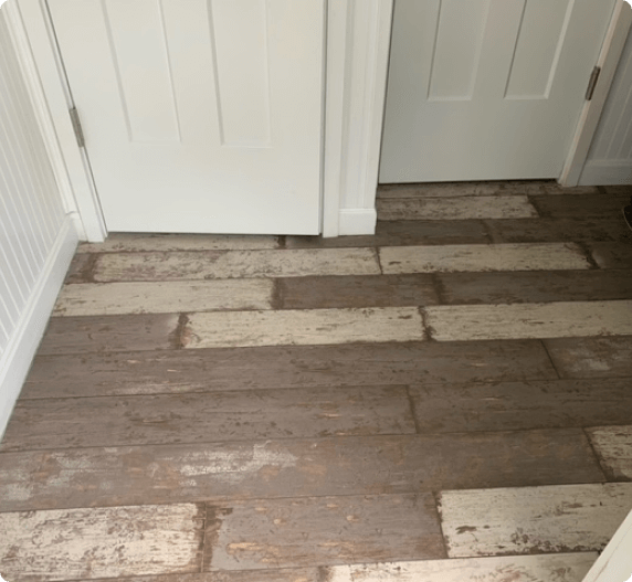 Wood plank flooring in entryway with two white doors.