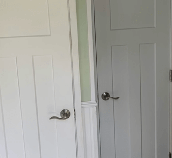Two white, paneled doors with silver handles.