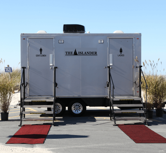Portable restroom trailer with steps and red carpet. 
