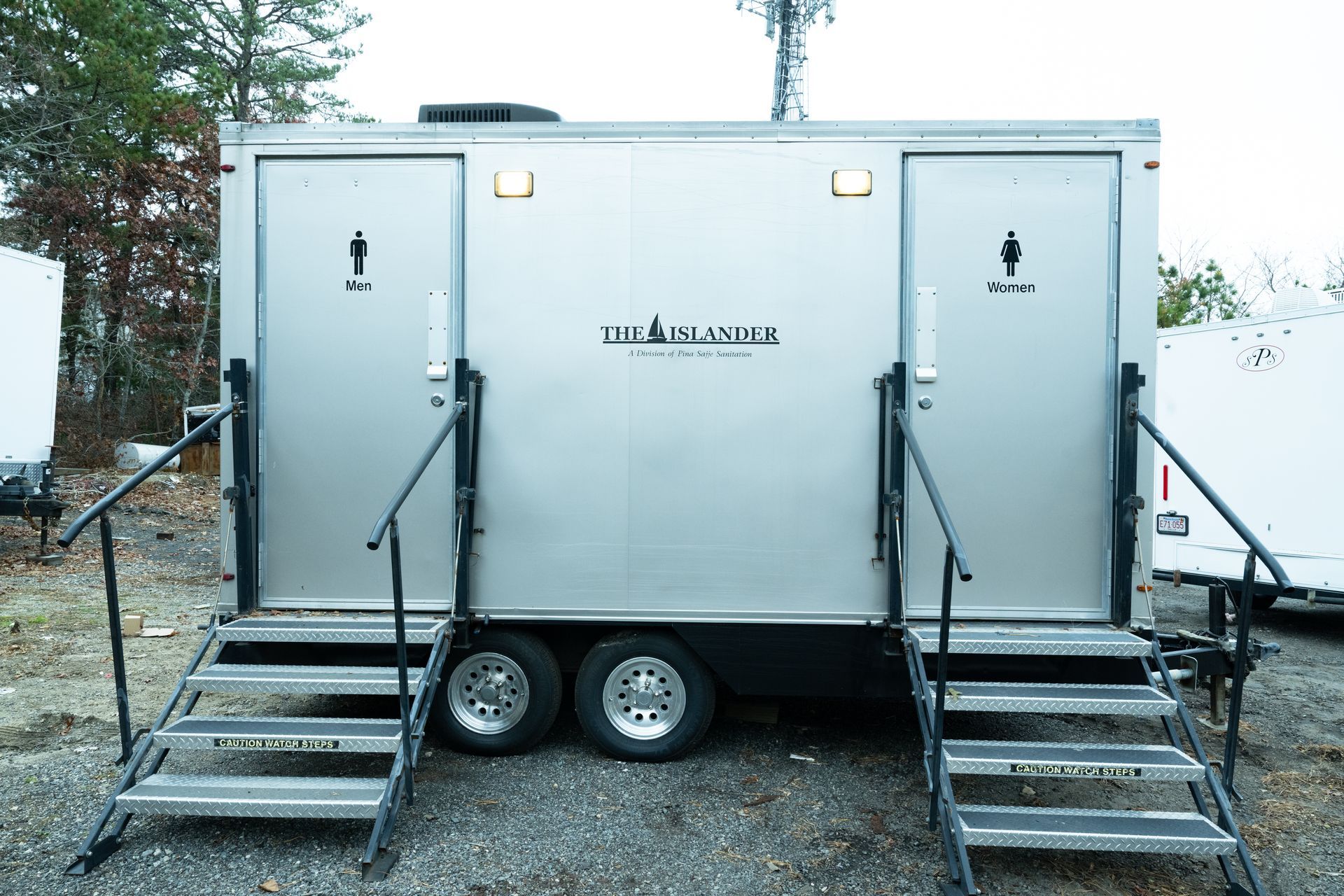 Portable restroom trailer with two entrances and steps.