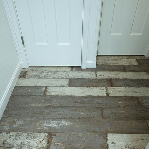 Worn gray-and-white plank floor in a hallway beside two white doors