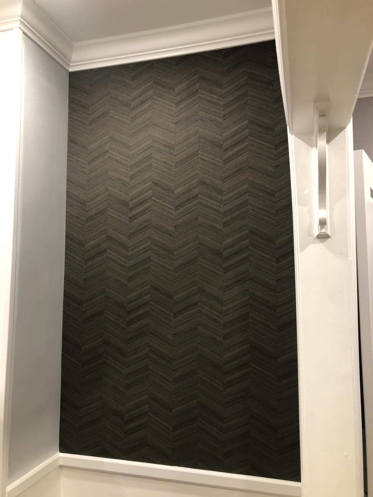 Empty hallway with a dark chevron-patterned accent wall and white trim