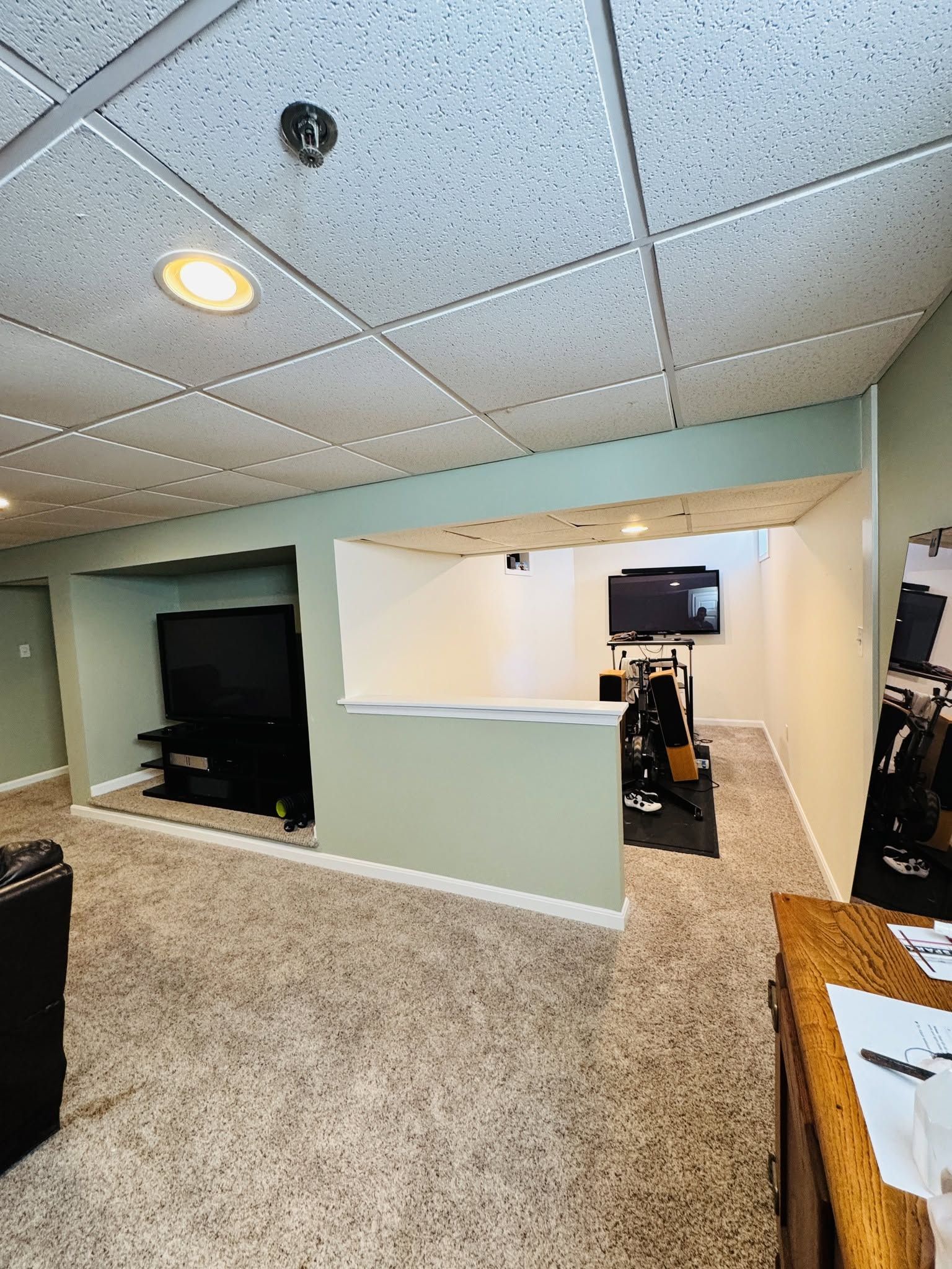 Office interior with drop ceiling, carpet, pass-through window, and a desk with papers in the foreground