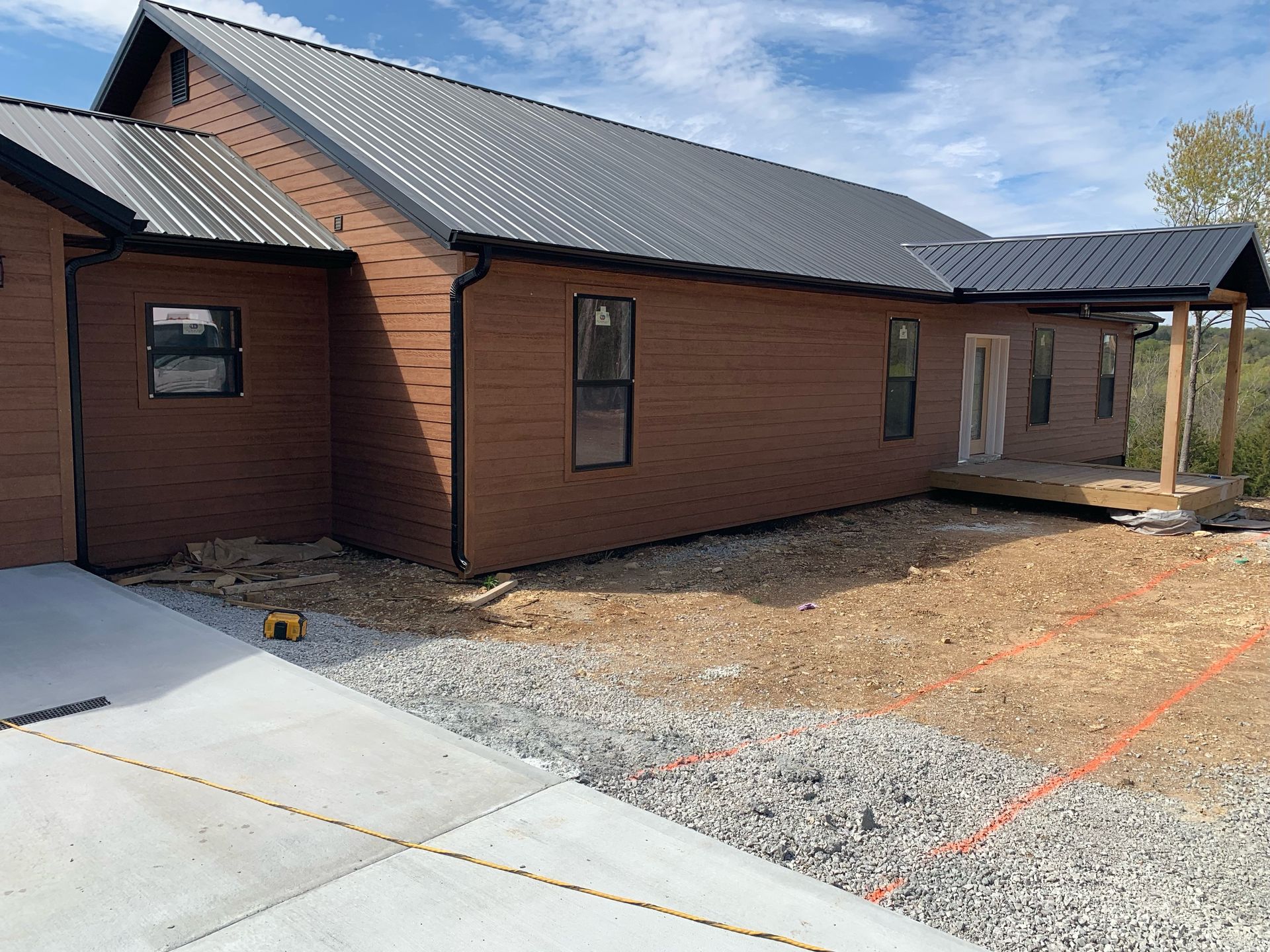A brick house with a metal roof is being built