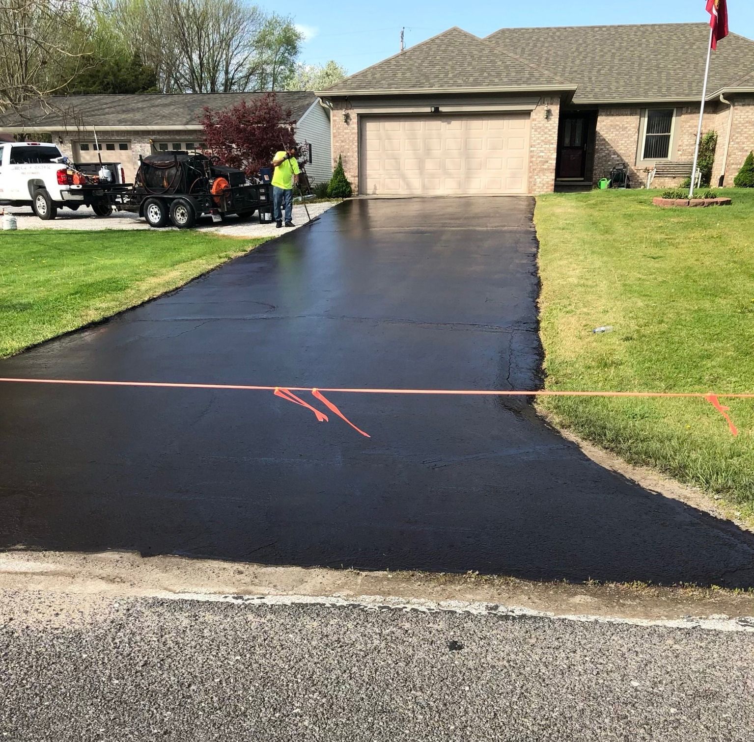 A driveway is being paved in front of a house