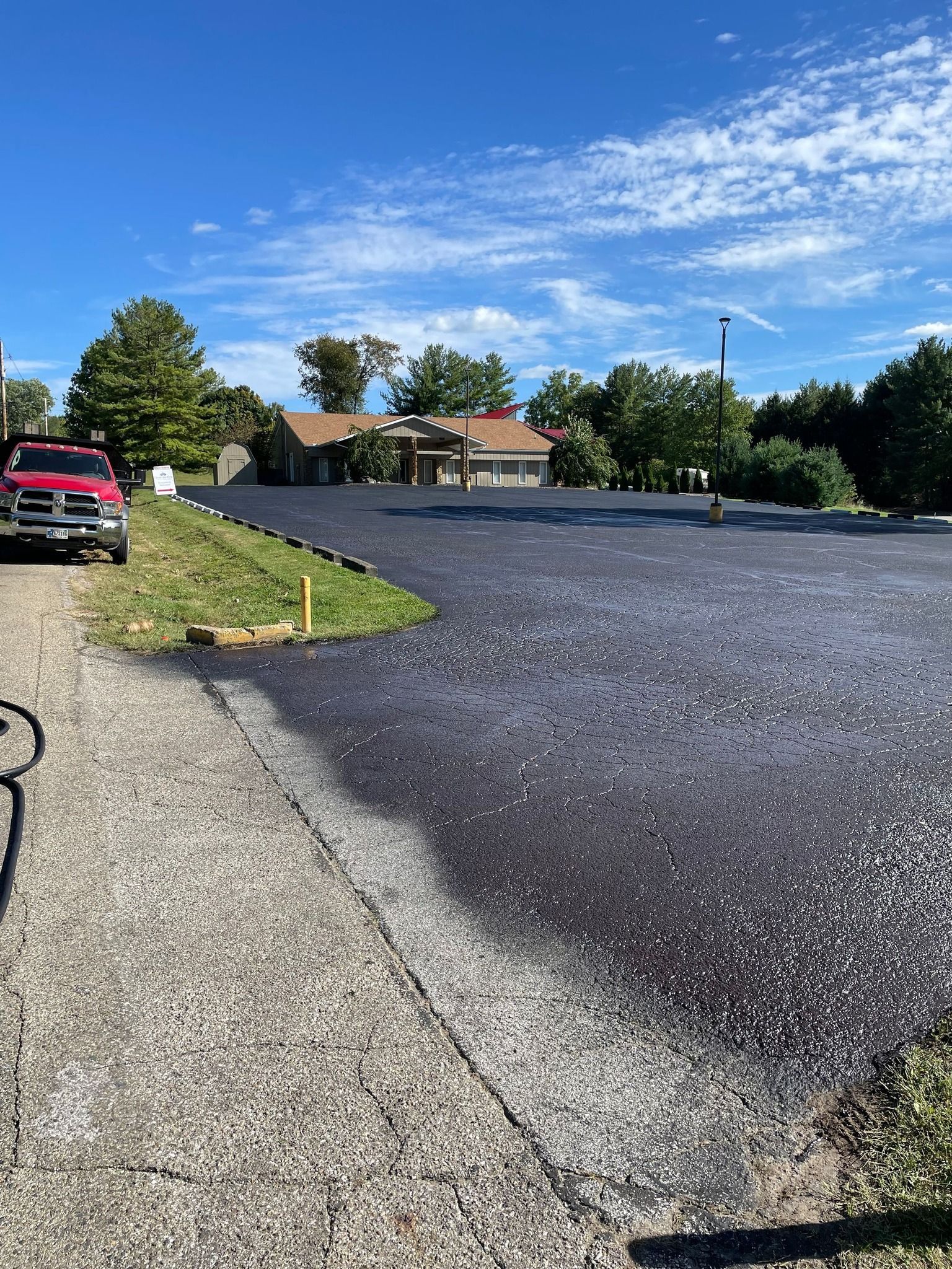 A red truck is parked in the middle of a parking lot.