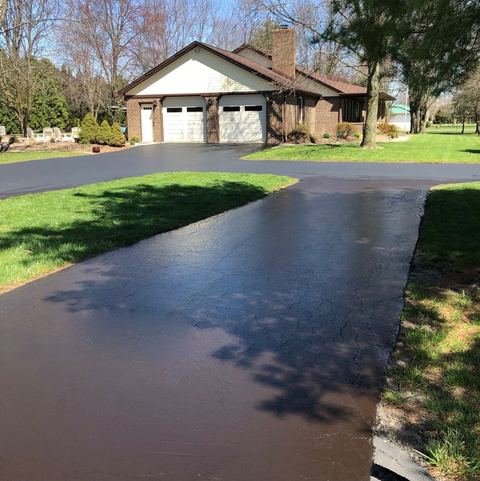 A driveway leading to a house with two garage doors.