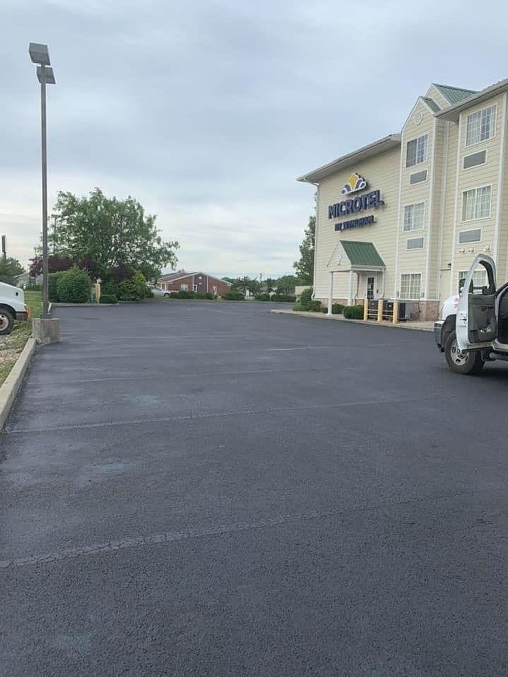 A truck is parked in a parking lot in front of a hotel.