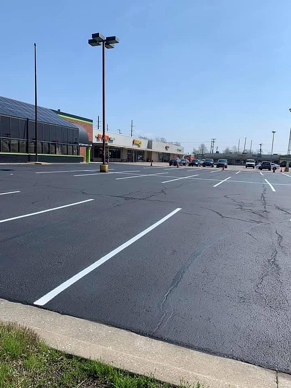 A parking lot with cars parked in front of a building.