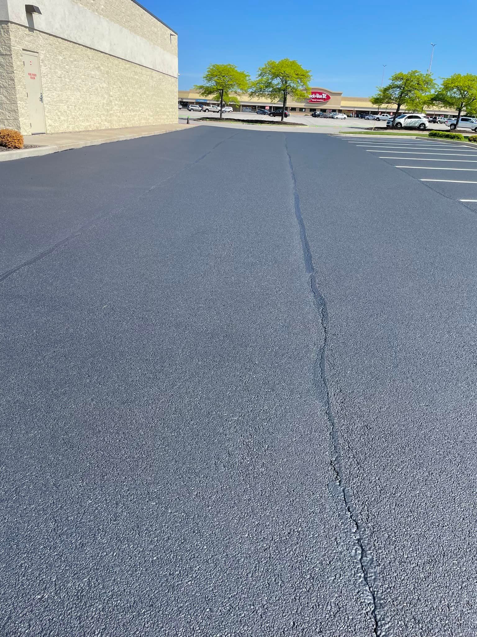 A parking lot with a lot of cars parked in it and a building in the background.