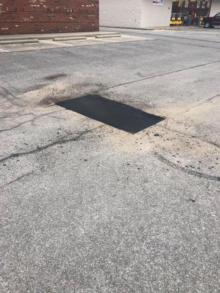 There is a hole in the ground in the middle of the road.