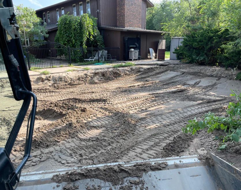 A large pile of dirt is sitting in front of a house.