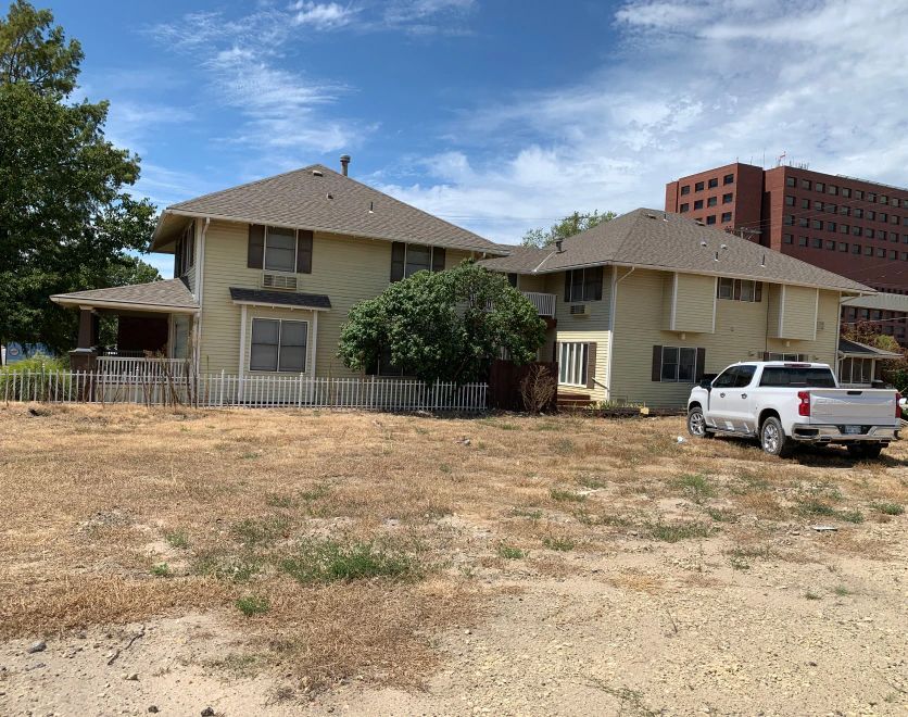 A white truck is parked in front of a house.