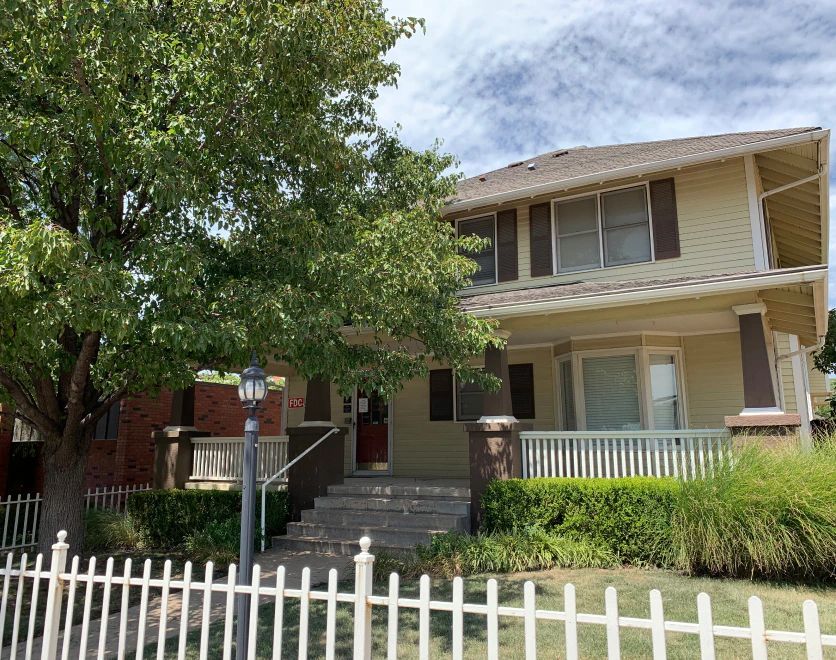 A house with a white picket fence in front of it