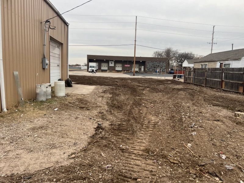 A dirt road with a building in the background.