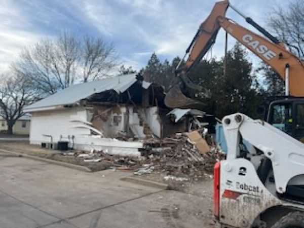 A case excavator is demolishing a house