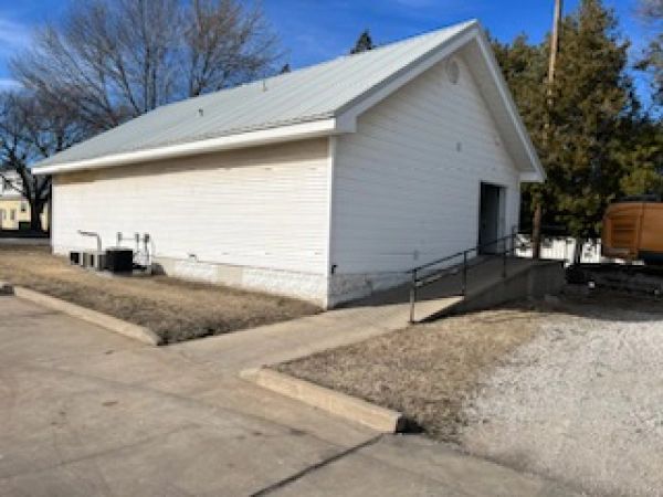 A small white building with a ramp leading to it