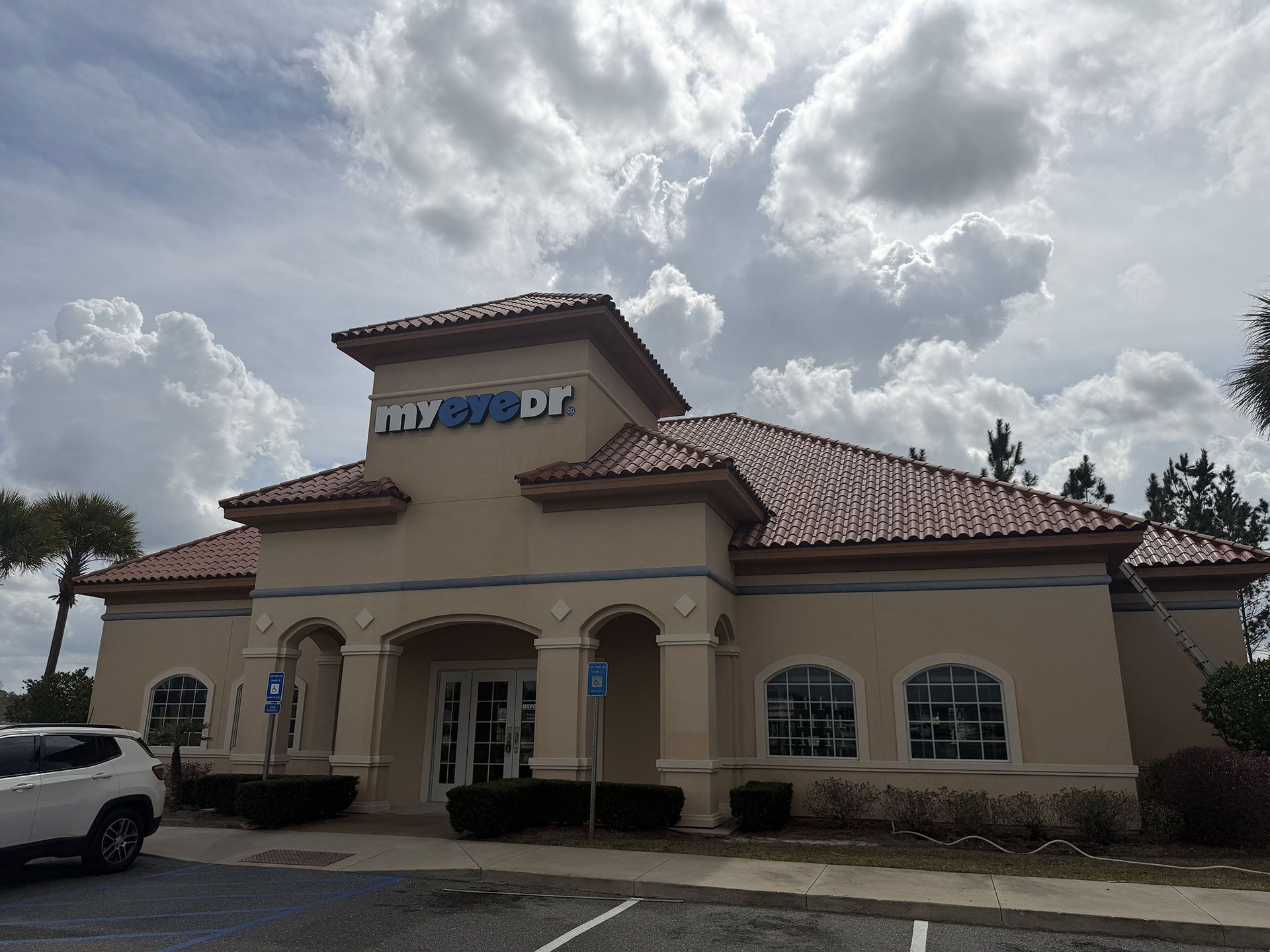 Spanish-style building with a red tile roof and cloudy sky, likely a restaurant or office.