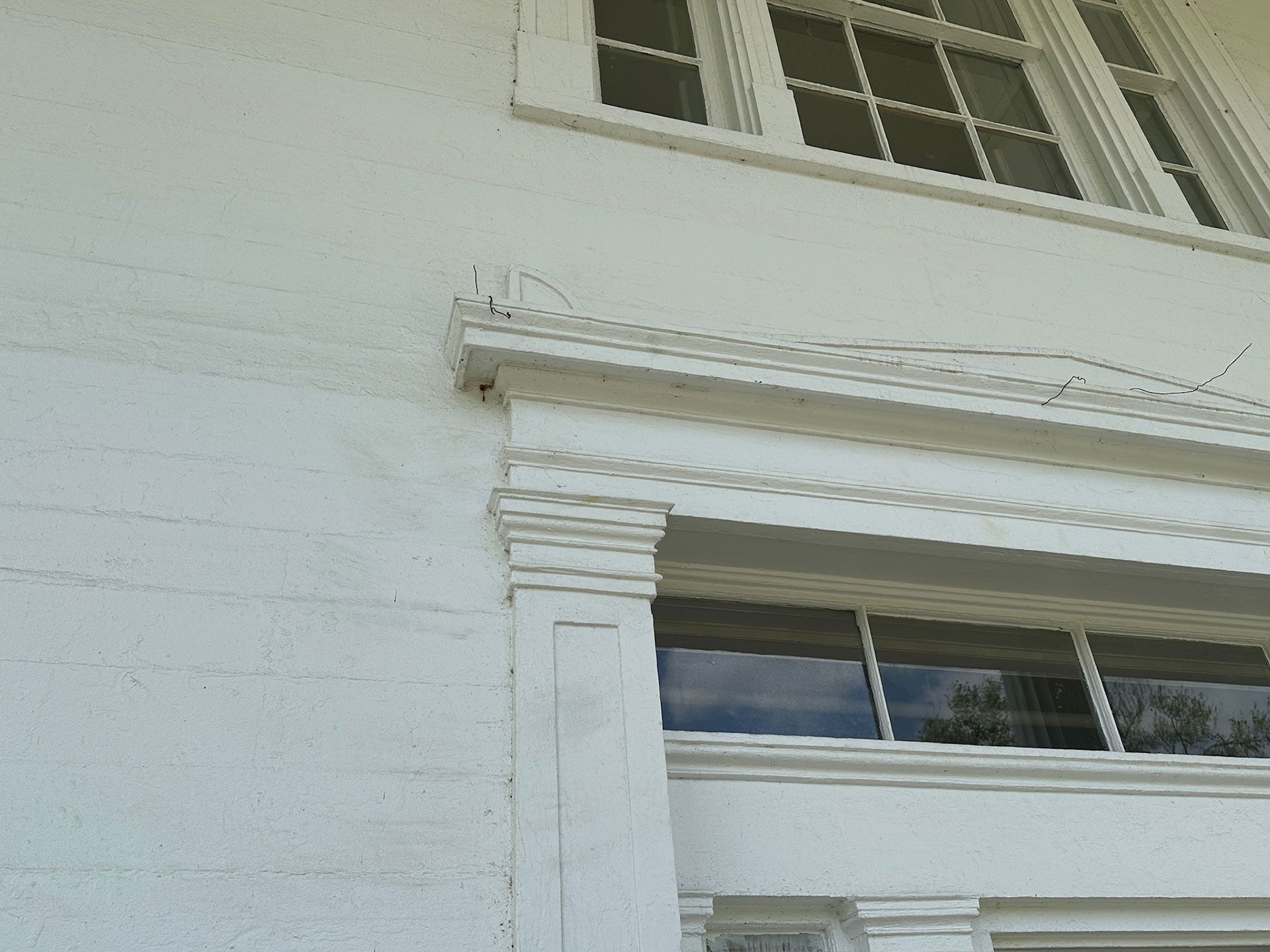 White house exterior with decorative trim, window, and siding detail
