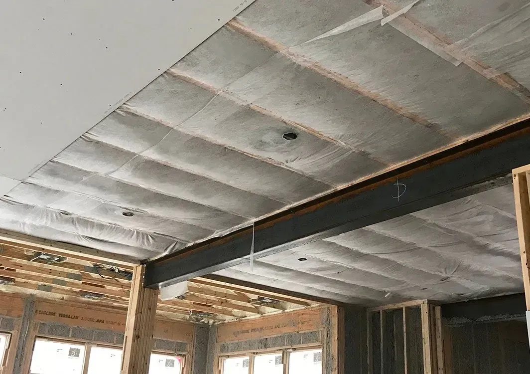 Ceiling with concrete panels and exposed steel beam during construction.