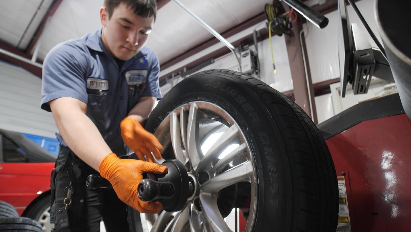 A man is working on a tire in a garage.