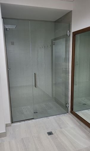 A bathroom with a glass shower door