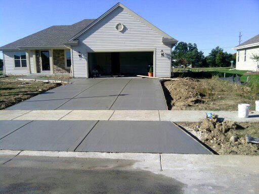A house with a concrete driveway in front of it