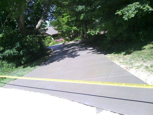 A concrete driveway with a yellow tape around it