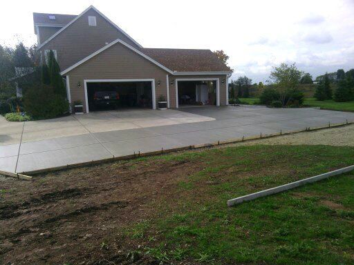 A large house with a concrete driveway in front of it
