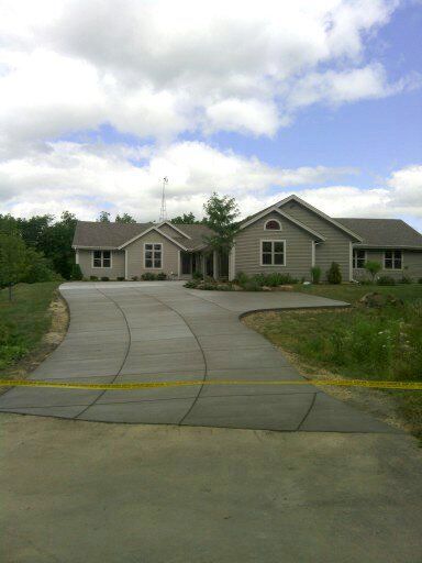 A large house with a concrete driveway leading to it
